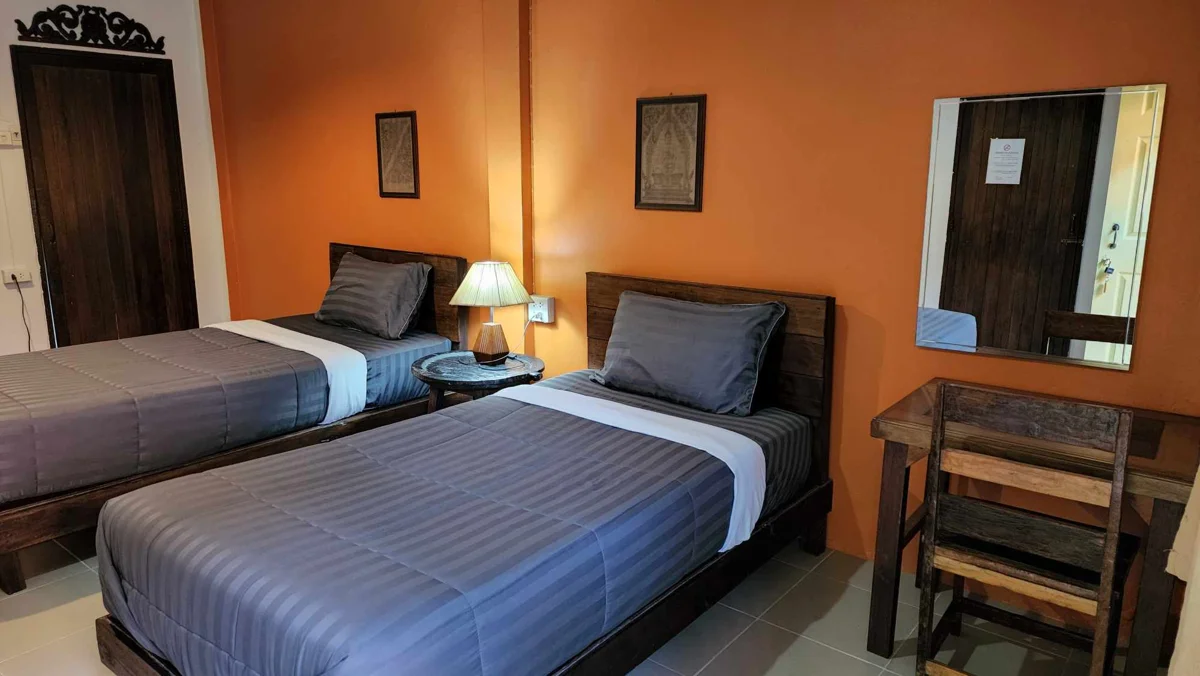 A guest room at The Outside Inn with two beds and wooden furnishings